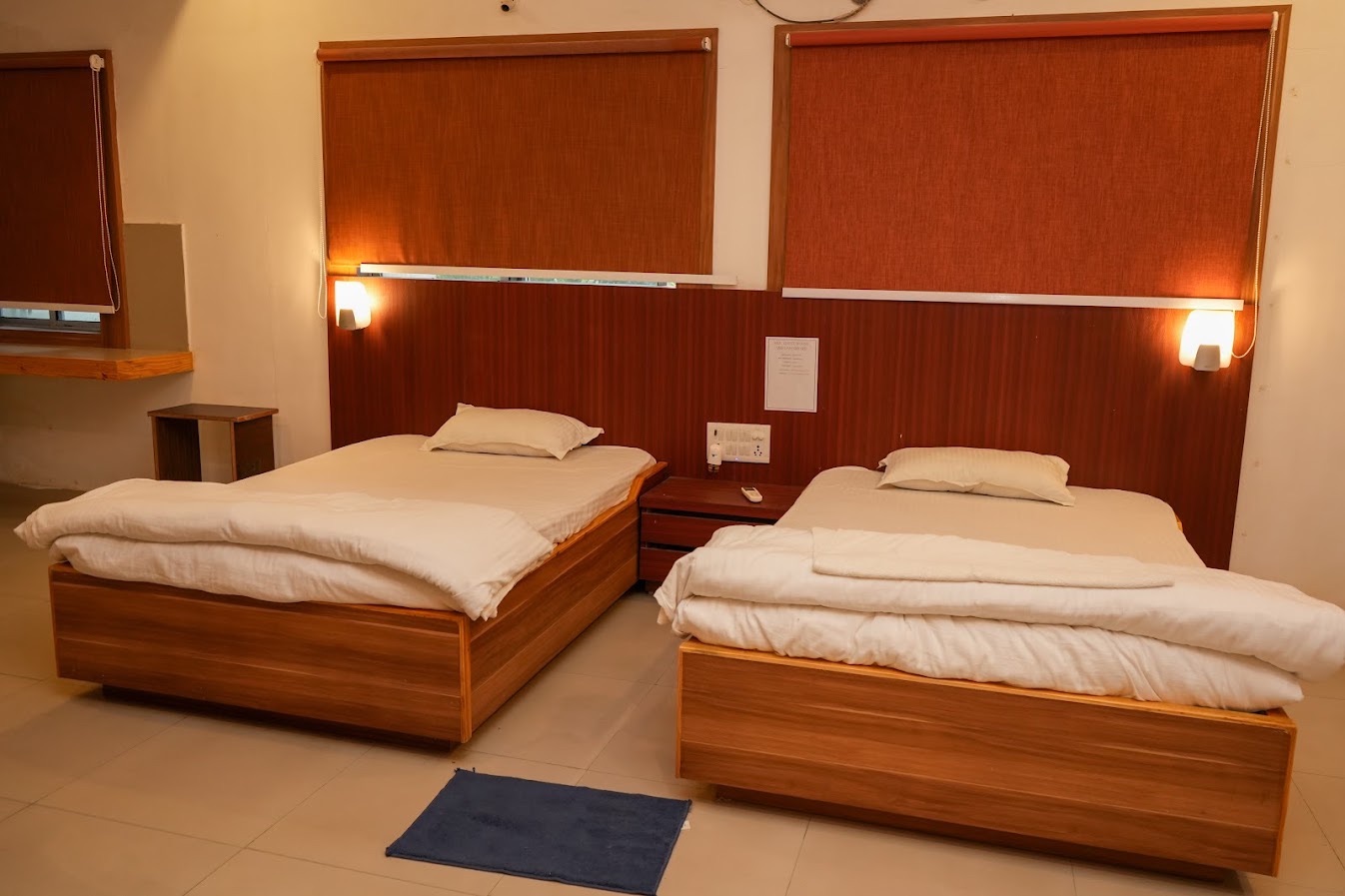 Twin-bed room with bedside table and warm lighting
